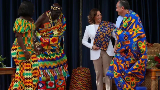 আক্রায় কামালা হ্যারিস এবং স্বামীকে ঘানার ঔতিহ্যবাহী পোশাক উপহার দেয়া হচ্ছে