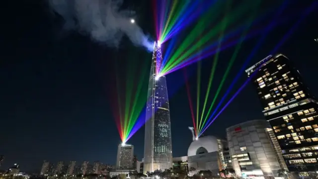 Güney Kore'nin Seul şehrindeki en yüksek bina olan Lotte World Tower'ın gece gökyüzüne lazer ışıkları hakim.