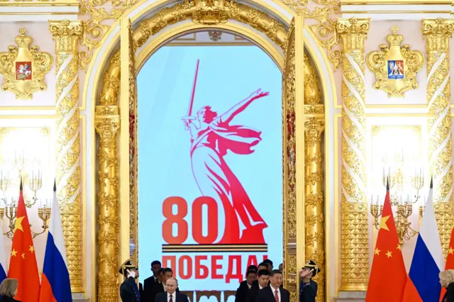 习近平和普京从一道金色的门两侧走进一个会场，两旁有中国和俄罗斯的国旗。