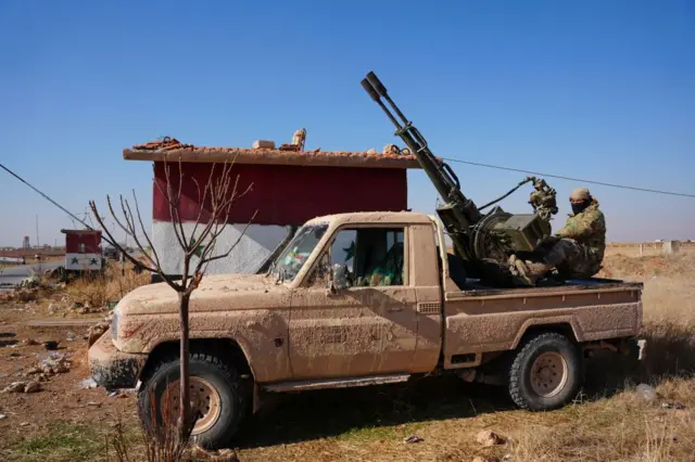 Bir arazi aracına monte edilen silahın üzerindeki HTŞ militanı.  