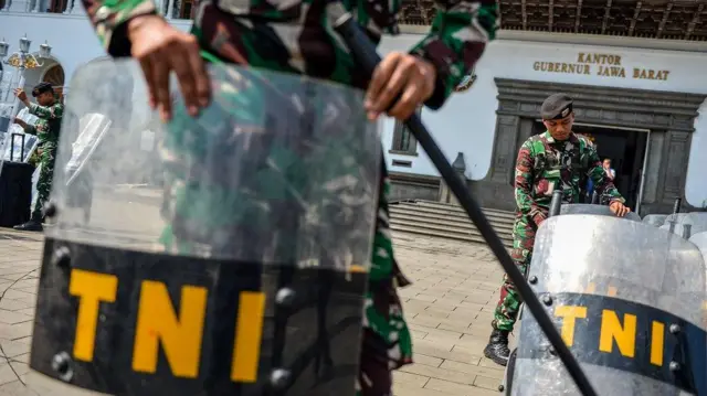 Anggota TNI merapikan tameng saat melakukan pengamanan di Gedung Sate, Bandung, Jawa Barat, Senin (1/9/2025). 