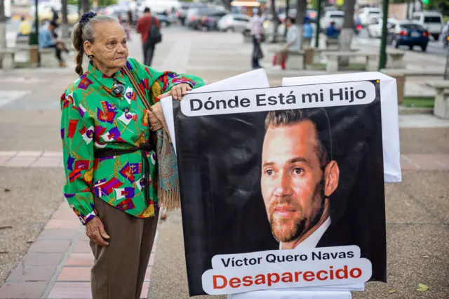 Carmen Navas sostiene un cartel que pone "Dónde está mi hijo. Víctor Quero Navas, desaparecido". La foto es del 4 de mayo de 2026.