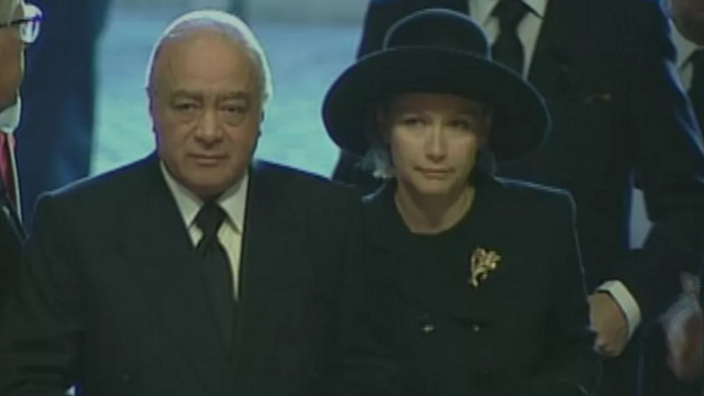 Al Fayed e a esposa Heini com roupas de luto, em pé