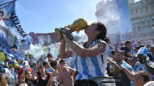 Slavlje navijača u Buenos Ajresu, argentinski navijali, navijači argentine, argentinka ljubi repliku trofeja svetskog fudbalskog šampiona