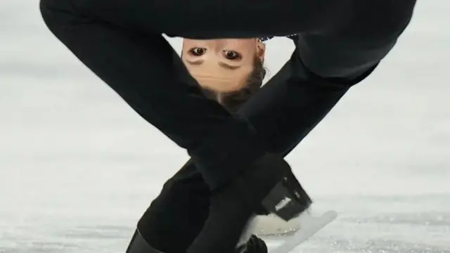 Голова німецької фігуристки Анніки Хоке майже торкається льоду, а очі пробиваються крізь трикутник ніг партнера під час обертання "смертельної спіралі". 