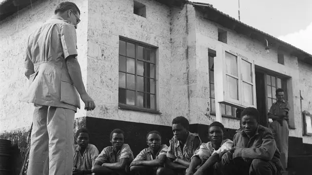 Des membres de la tribu des Kikuyus soupçonnés d'appartenir au mouvement Mau-Mau sont interrogés par un inspecteur de police. 1952.