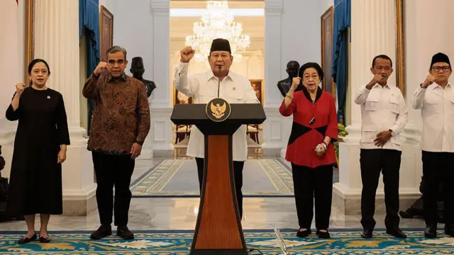 雅加達總統府內，普拉博沃·蘇比安托總統與各政黨領袖並肩而立。普拉博沃在講台上發表講話，舉起拳頭——照片中其他政治領袖也紛紛效仿。