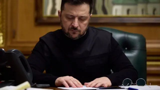 Зеленський сидить за столом