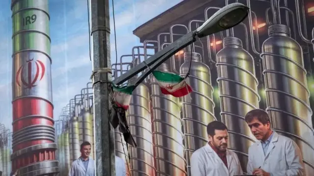 تہران میں آویزاں ایک پوسٹر پر یورینیم افزودگی کے آلات اور جون 2025 میں اسرائیلی حملوں میں ہلاک ہونے والے ایرانی سائنس دانوں کی تصویر بنائی گئی ہے
