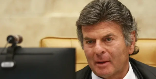 Imagem de Luiz Fux em frente a uma tela de computador durante julgamento no STF