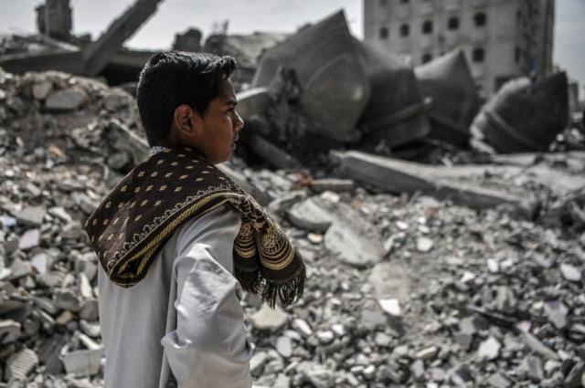 Un joven en Gaza observa los escombros de una mezquita destruida por un ataque israelí