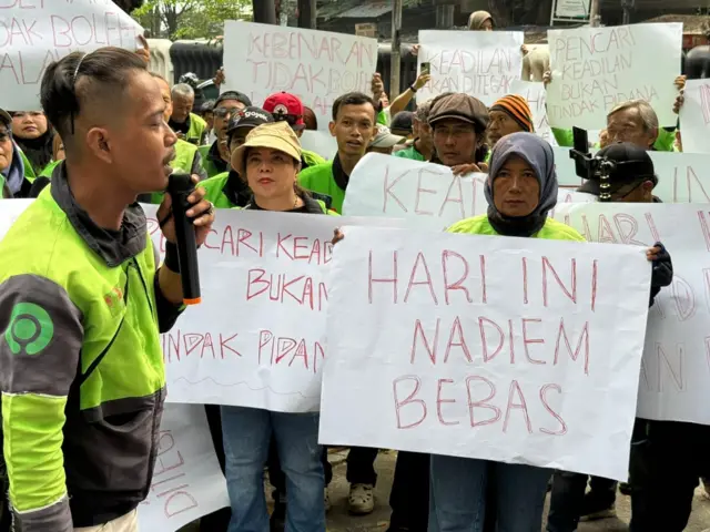 Sejumlah pengemudi mitra Gojek membentangkan poster di luar Pengadilan Tindak Pidana Korupsi, Jakarta Pusat, Selasa (30/06). 