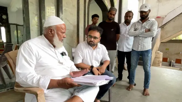 शेख ईस्माईल पापामियां आणि बाकी राहणारे स्थानिक त्यांची बाजू आम्हाला सांगतात.