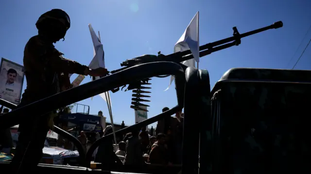 Солдат с пулеметом у мечети в Сане на похоронах высокопоставленных хуситов, убитых в результате авиаудара США в декабре 2025 года