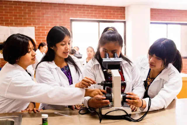 Alumnas con un microscopio