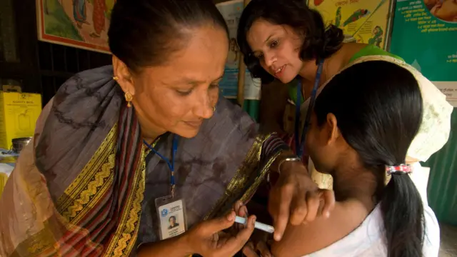 আট বছরের মেয়ে শিশুকে টিকা দেয়া হচ্ছে