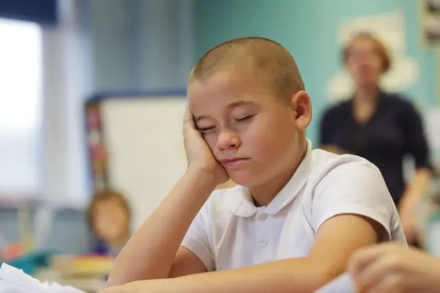 یک پسربچه در کلاس درس چرت می‌زند