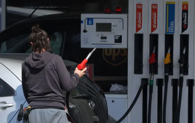 Žena toči gorivo na pumpi