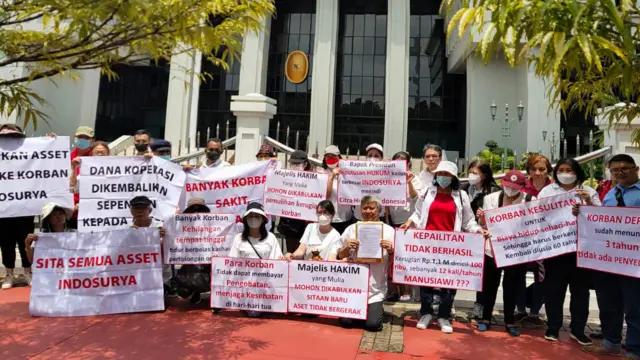 Aliansi korban investasi KSP Indosurya berdemo memegang spanduk menuntut keadilan. 