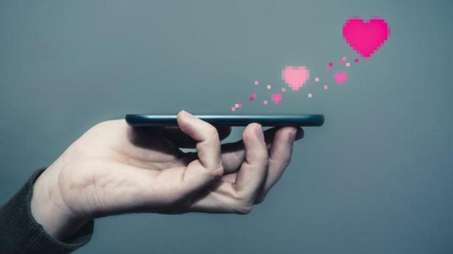 Pessoa segurando celular com símbolos gráficosbetano site de apostascoração