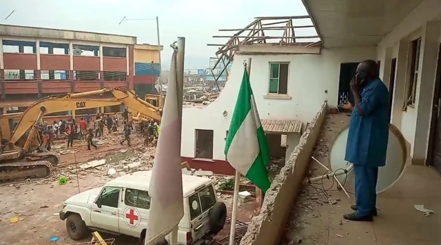 Otu onye isi na ndị ọrụ Red Cross nọ n'elu ụlọ oge a na akwụtụ ụlọ ha