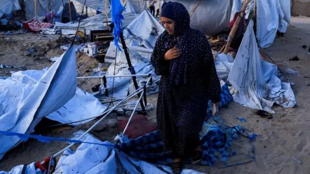 ইসরায়েলি হামলার পর দক্ষিণ গাজার খান ইউনিসে ধ্বংসপ্রাপ্ত তাঁবু দেখছেন একজন ফিলিস্তিনি নারী