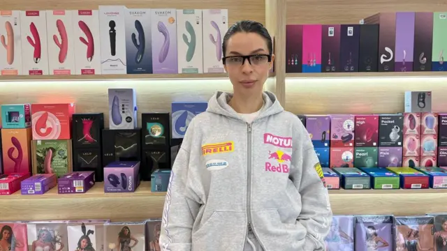 Катерина, співвласниця Intimate Company, в своєму магазині. Позаду помітний великий арсенал секс-іграшок