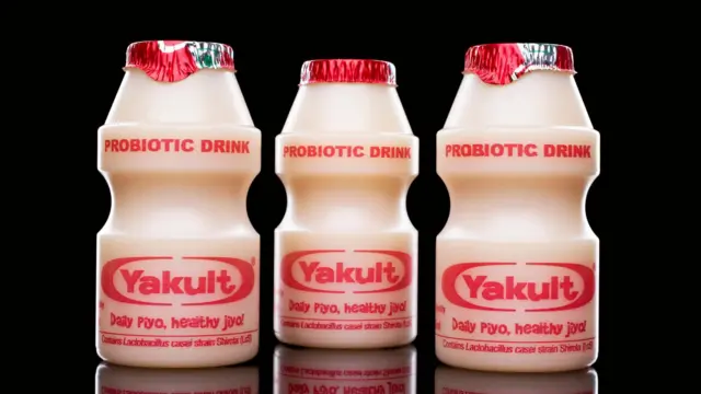 Garrafinhas de Yakult fechadas, com dizeres para venda na Índia