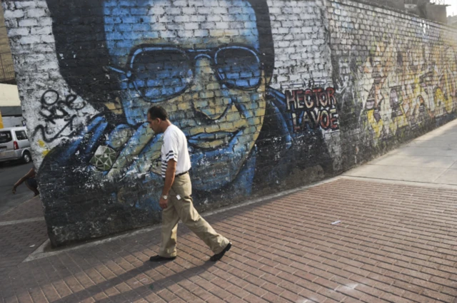 Un hombre pasa junto a un mural de Héctor Lavoe en Lima. 
