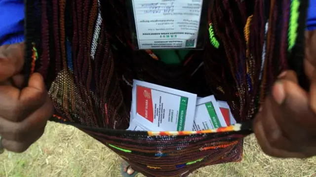 Saksi menunjukkan kertas suara yang dimasukkan ke noken saat pemilu presiden dan legislatif di Kabupaten Jayawijaya, Provinsi Papua Pegunungan, Rabu (14/02).