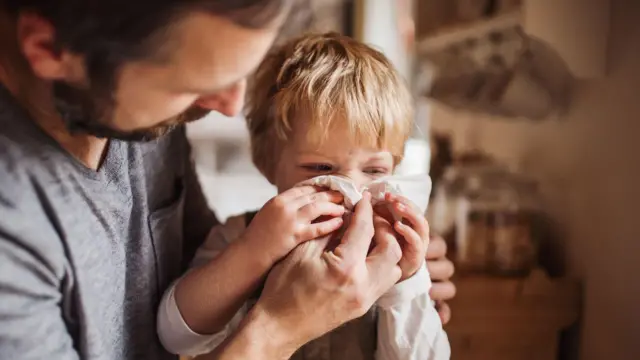 дитина чхає в серветку