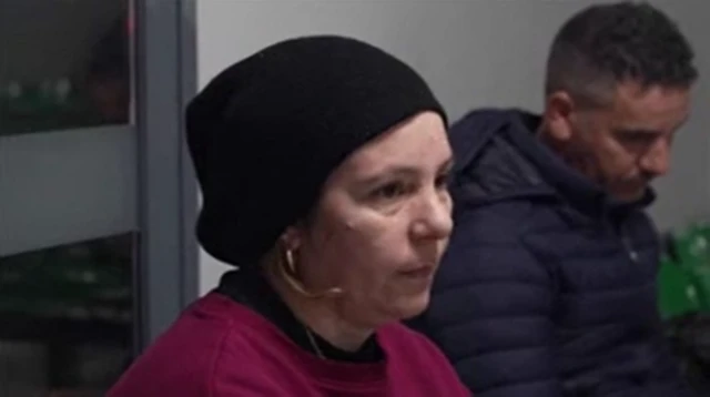 Karina y Ahmed esperan sentados en sillas de plástico verde en el hospital.