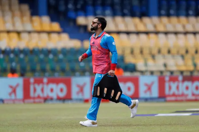 ভিরাট কোহলি শুক্রবারের ম্যাচে খেলেন নি, কিন্তু একবার জল নিয়ে তাকে মাঠে নামতে দেখা গিয়েছিল