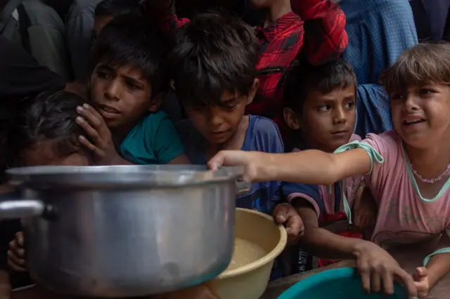 Centenas de moradores de Gaza aguardam por comida em cozinha beneficente, Cidade de Gaza – 18 de maio de 2025