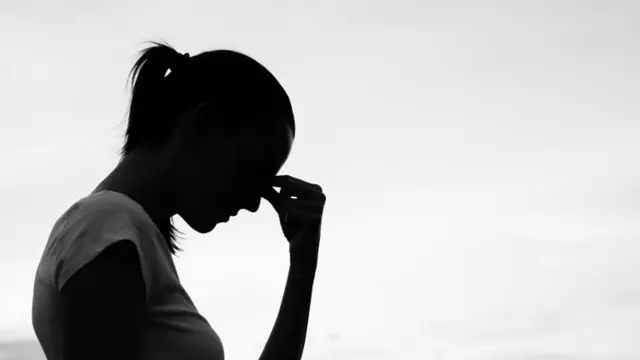 በጥላ ውስጥ ሆና የምትታይ ሴት