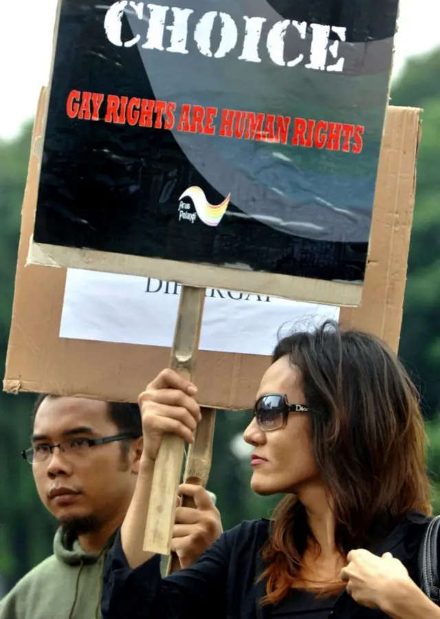 Seorang waria Indonesia memegang plakat selama demonstrasi untuk kesetaraan hak yang menandai hari hak asasi manusia, di Jakarta, 10 Desember 2006.