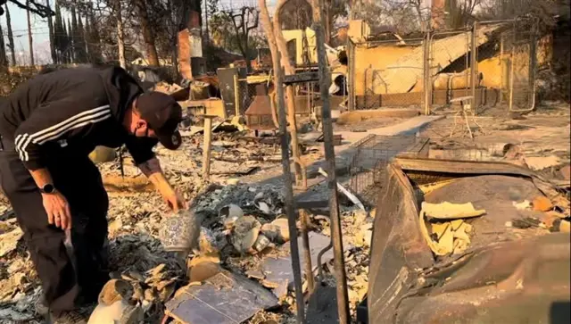 Homemaposta artilheiro copatrajeaposta artilheiro copapasseio preto inclinando-se e segurando um vasoaposta artilheiro copameio a ruínas queimadas 