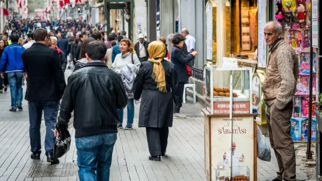 Taksim İstiklal Caddesi'nin kalabalık halinden bir görüntü. Yanda bir simir satıcısı görünüyor
