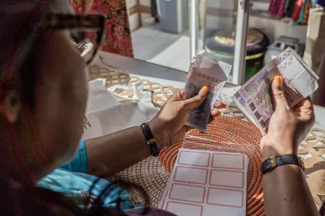 Un commerçant compte les billets de francs ouest-africains (CFA) à Dakar, au Sénégal, le lundi 3 juin 2024. 