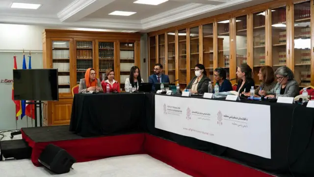 تصویر از جریان دادگاه در ماه اکتوبر. در این تصویر پنج قاضی در سمت راست تصویر نشسته اند و به سخنان دادستانها که در سمت چپ نشسه اند گوش می‌دهند. 