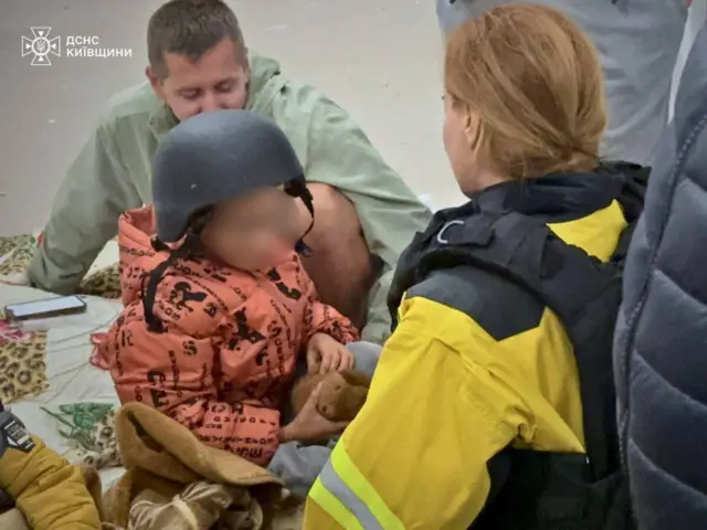Рятувальники допомагають дитині після нічної атаки на Київ 
