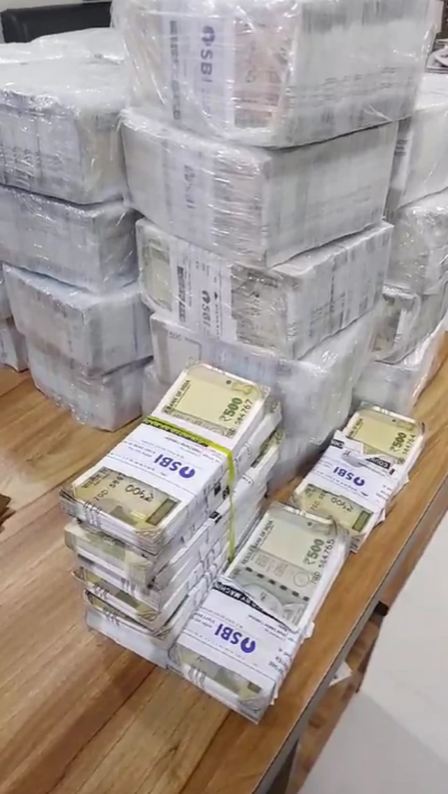 તપાસ દરમિયાન ટેબલ ઉપર મૂકવામાં આવેલી નોટોની થોકડીની તસવીર 