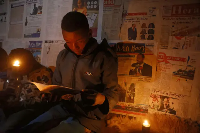 በኩራዝ ብርሃን የሚያነብ ታዳጊ