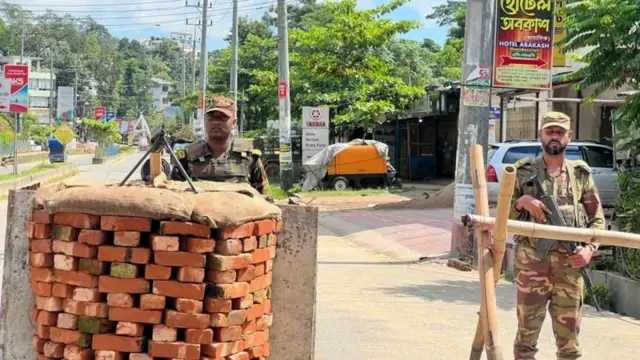 রাস্তায় বেরিক্যাড দিয়ে অস্ত্র হাতে দাঁড়িয়ে আছে সেনাবাহিনীর দুই সদস্য