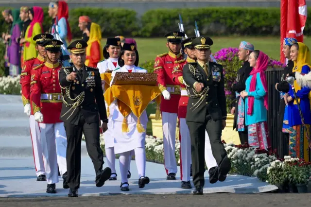 El escuadrón de izamiento de la bandera lleva la histórica primera bandera de Indonesia desde el Monumento Nacional en Yakarta hasta Nusantara.