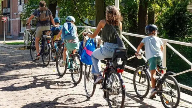 Una pareja con sus tres niños paseando en bicicleta en Holanda