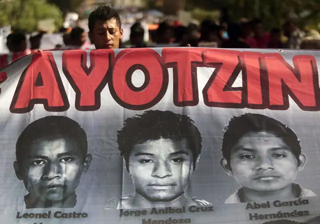 Una pancarta con rostros de tres estudiantes desaparecidos de Ayotzinapa