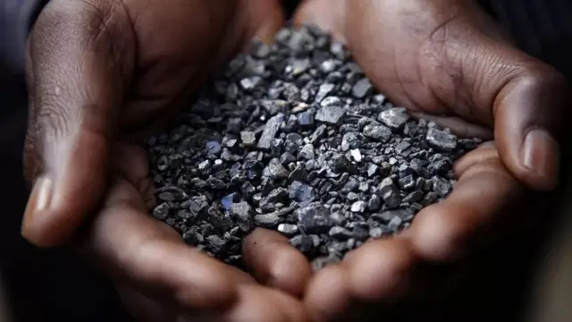 Une poignée de coltan dans deux mains.