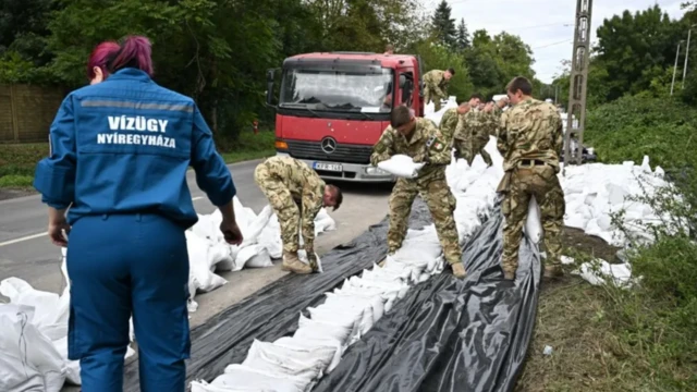 Венгерские солдаты в деревне Леанифалу помогают возводить заграждения от наводнений с помощью мешков с песком 