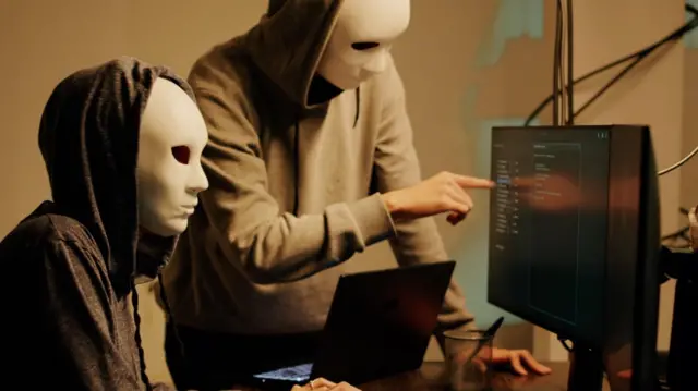 তথ্য চুরি করছে মুখোশ পরা দুইজন হ্যাকার 